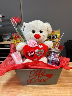 a valentine's day gift basket with a white teddy bear holding a red heart