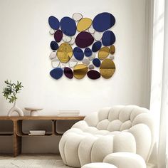 a white chair sitting in front of a wall with circles on it's back