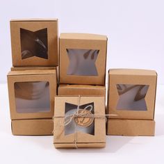 four boxes with brown paper and twine tied around them, each containing a photo