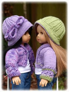 two dolls are wearing knitted hats and sweaters