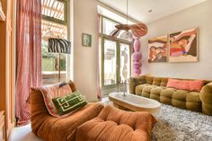 a living room filled with lots of furniture and art work on the wall above it