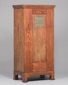 an old wooden cabinet with green designs on the front and side panels, sitting against a gray background