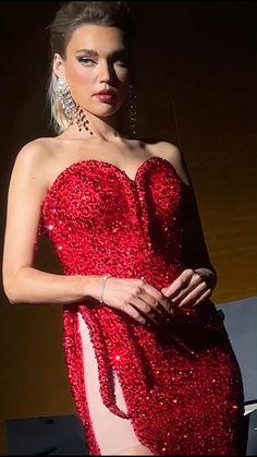 a woman in a red sequined dress posing with her hands on her hips