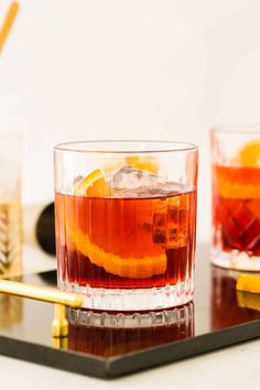 two glasses filled with orange slices on top of a table