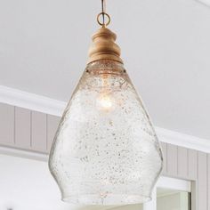 a light fixture hanging from the ceiling in a room with white walls and wood trim