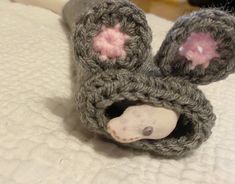 a crocheted mouse is laying on the bed