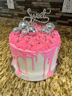 a birthday cake with pink frosting and decorations