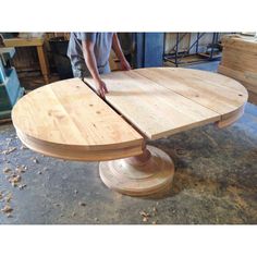 a man working on a wooden table in a shop