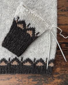 a white and black knitted object on top of a wooden table