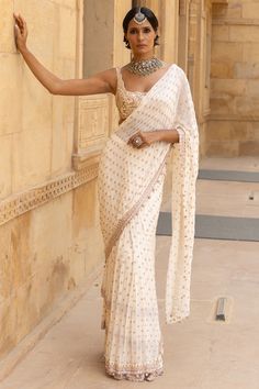 Arpita Mehta features a mesmerizing White Saree Set that captivates with its elegance. The eye-catching saree is crafted in georgette with mirror, sequins and cutdana hand embroidery. It is paired with a net blouse. Accessorize the designer saree set with statement earrings and heels for weddings, showcasing style and sophistication.#Perniaspopupshop #womenswear #ethnic #whatiworewastrending #ppuslove #sareeset #Net #handembroidery #Georgette #weddingwear #festivewear Embroidery Mirror, Net Blouses, Pleated Drapes, Blouse For Women