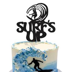 there is a cake with a surfer on it and the words surf's up