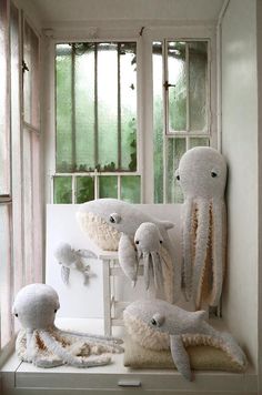 several stuffed animals sitting on a window sill