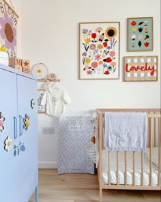 a baby's room with two cribs and pictures hanging on the wall