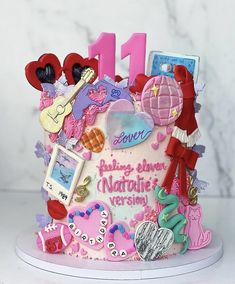 a pink birthday cake with lots of decorations