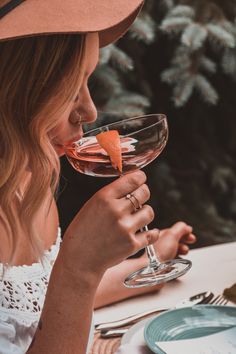 a woman wearing a cowboy hat drinking wine