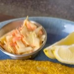 a plate with some food on it and a lemon wedge next to the side dish