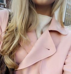 a woman wearing a pink trench coat and hat