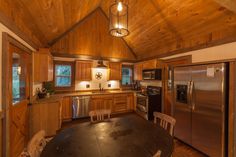 a kitchen with wood paneling and stainless steel appliances in the middle of the room