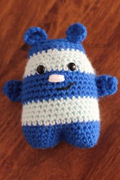 a blue and white stuffed animal sitting on top of a wooden table