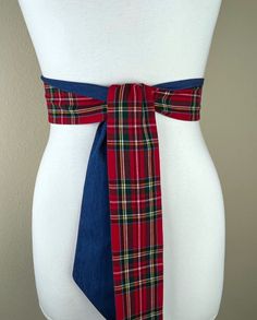 "Royal Stewart Tartan & Denim  Sash Belt  Red Plaid and Denim Belt  Red Tartan and Denim Sash Belt  Red Plaid Sash, Tartan Belt  Refresh your casual look with this Satin Swank® tartan and denim waist sash. Depending on your waist size and the length you choose you can wrap this sash around your waist once or twice. You decide whether to tie the sash in a bow or a simple knot with long-hanging tails. Tie in front, in back, or on the side. Yarn-dyed cotton twill fabric in Royal Stewart tartan on one side and medium wash denim on the reverse side. Sash is constructed (hand cut & sewn by Satin Swank®) in one long piece, ends are finished on the angle and seams are hidden within the fold lines. SIZING/COLOR/PRINT INFO: The mannequin pictured is wearing the 60 inch sash length and has a 28 inch Royal Stewart Tartan, Stewart Tartan, Waist Sash, Denim Belt, Sash Belts, Red Tartan, Sash Belt, Suspender Belt, Twill Fabric