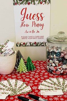 a table topped with lots of christmas decorations and paper snowflakes next to a sign