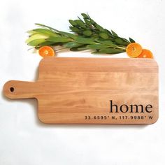 a cutting board with an orange on top and the words home written in black ink