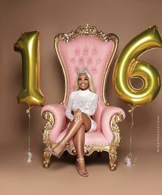 a woman sitting on a pink chair with gold balloons in the shape of number 16