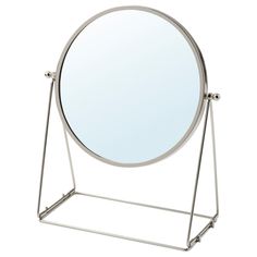 a round mirror sitting on top of a metal stand