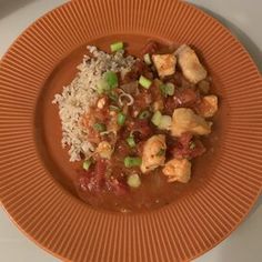 an orange plate topped with rice and meat