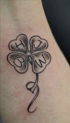 a four leaf clover tattoo on the back of a woman's neck and shoulder