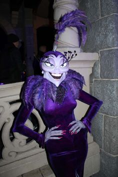 a woman in a purple dress and mask