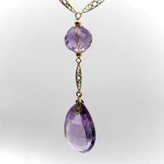 This is part of Chairish’s Fine Jewelry assortment.  The hand faceted Rose de France amethyst beads in this 14k gold Edwardian necklace have stunning facets that catch the light like prisms. The center stone is a flattened teardrop-shaped briolette with elongated triangular facets. The round beads along the chain descend in size; each are hand faceted and subtly different in shape, like tulip bulbs. The stones are the pale purple that Rose de France is known for—a lighter colored amethyst with softer tones that are romantic and feminine. The amethyst beads are sandwiched between 14k gold wirework, held together by traditional French fancy links—narrow almond shaped links with intricate filigree work. Circa 1915, the lace like quality of this necklace is very elegant but also suggests a mov Edwardian Necklace, Tulip Bulbs, Pale Purple, Almond Shaped, Amethyst Beads, Prisms, Gold Gold, Bead Necklace, Gold Rose