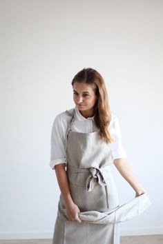 a woman wearing an apron holding something in her hands