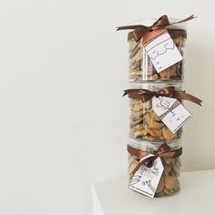 three glass containers filled with cookies and wrapped in brown ribbon