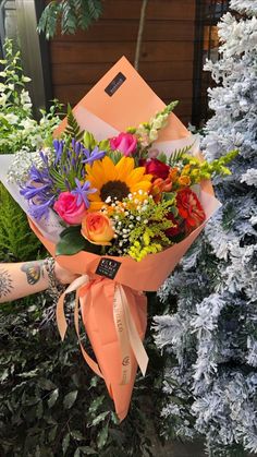 a woman holding a bouquet of colorful flowers