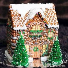 a gingerbread house with trees and snow on the roof