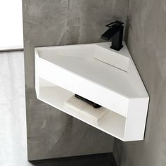 a bathroom sink with a black faucet on the top and a white shelf below it