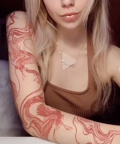 a woman with tattoos on her arm posing for the camera