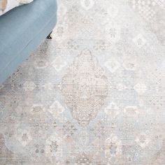 a blue couch sitting on top of a wooden floor next to a white and gray rug