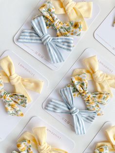 four bows with flowers on them sitting on top of a white table next to each other