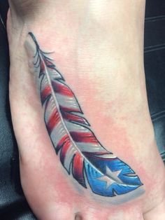 a foot with an american flag feather tattoo on it