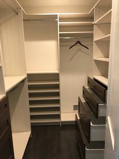 an empty walk in closet with drawers and shelves