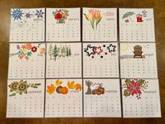 six calendars with different designs on them sitting next to each other in front of a wooden table