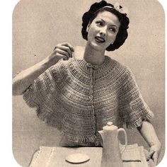 an old photo of a woman sitting at a table with a teapot and cup