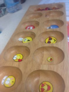 a wooden table topped with lots of bowls filled with cartoon faces on it's sides