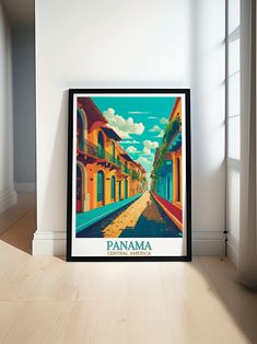 a framed poster is sitting on the floor in front of a white wall and window