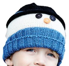 a young boy wearing a blue and white knitted hat with buttons on the side