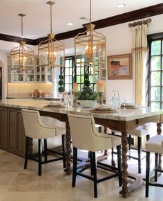 a large kitchen with marble counter tops and white chairs in front of an island that is surrounded by windows