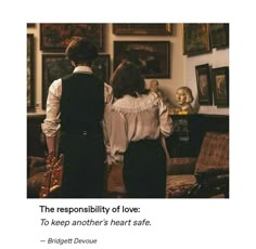 two people standing next to each other in front of pictures and a quote on the wall