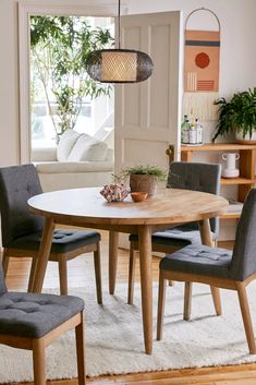 a dining table with four chairs and a potted plant